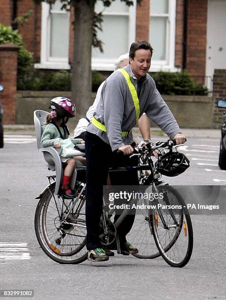 Conservative party leader David Cameron cycles his daughter Nancy to school on his way to the House of Commons, London.