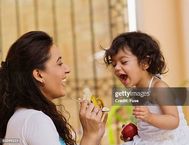 mother feeding little girl - indian mother feeding baby stock pictures, royalty-free photos & images