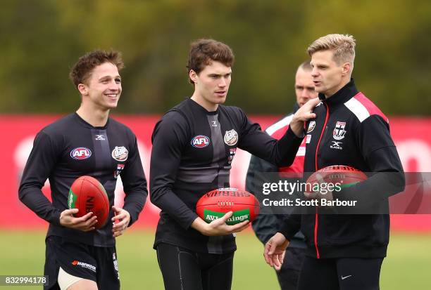 Jack Billings of the Saints, Blake Acres of the Saints and Nick Riewoldt of the Saints talk during a St Kilda Saints AFL training session at Linen...