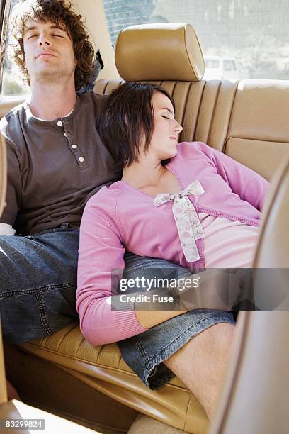 couple napping in back seat of car - couple sleeping in car photos et images de collection
