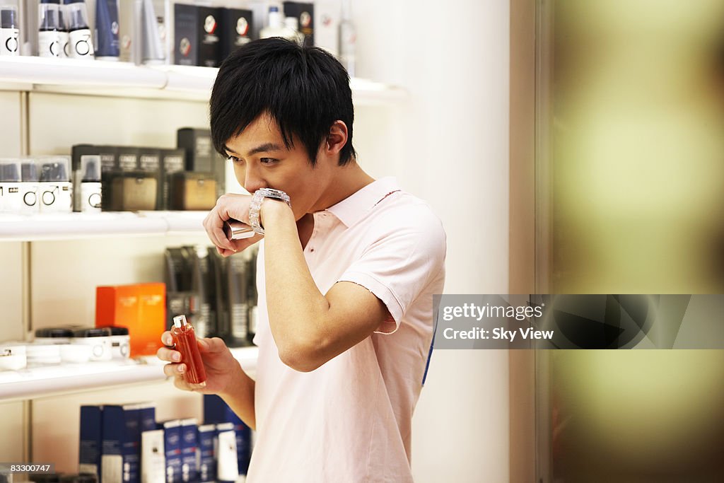 Man smelling aftershave in retail store
