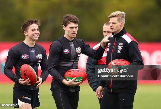 Jack Billings of the Saints, Blake Acres of the Saints and Nick Riewoldt of the Saints talk during a St Kilda Saints AFL training session at Linen...