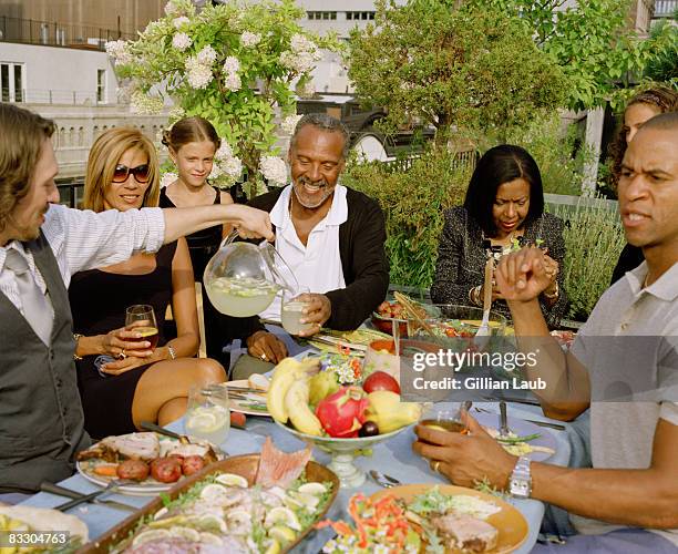 generations of family having dinner on rooftop. - familientreffen stock-fotos und bilder