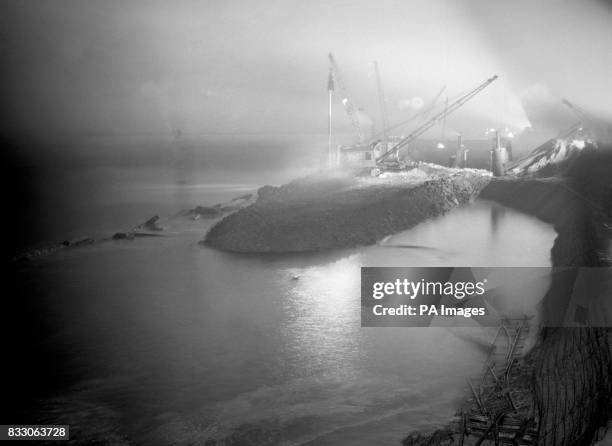 Searchlights play into the sky and shed a canopy of refelcted light on the 'danger' high tide, and the battle against it, to make this dramatic scene...