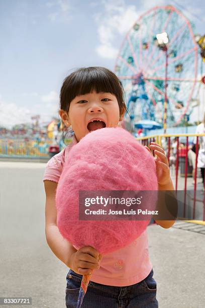 young girl at the fair eating cotton candy - candy floss stock pictures, royalty-free photos & images