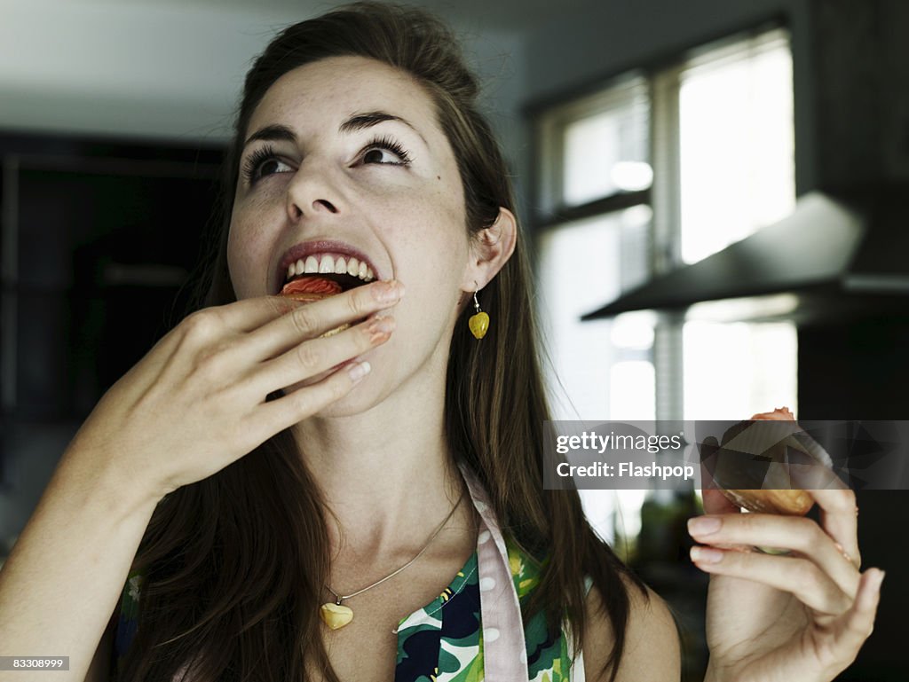 Portrait of woman eating cup cakes
