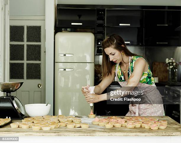 portrait of woman icing cup cakes - young women group back stock-fotos und bilder