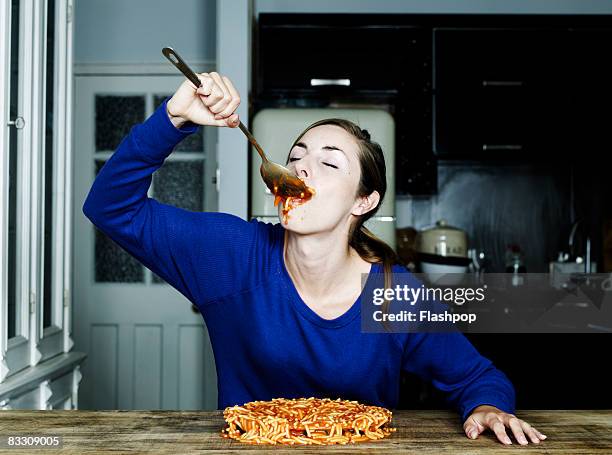 portrait of woman eating spaghetti - over eating fotografías e imágenes de stock