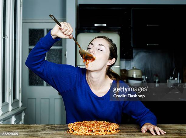 portrait of woman eating spaghetti - plate eating table imagens e fotografias de stock