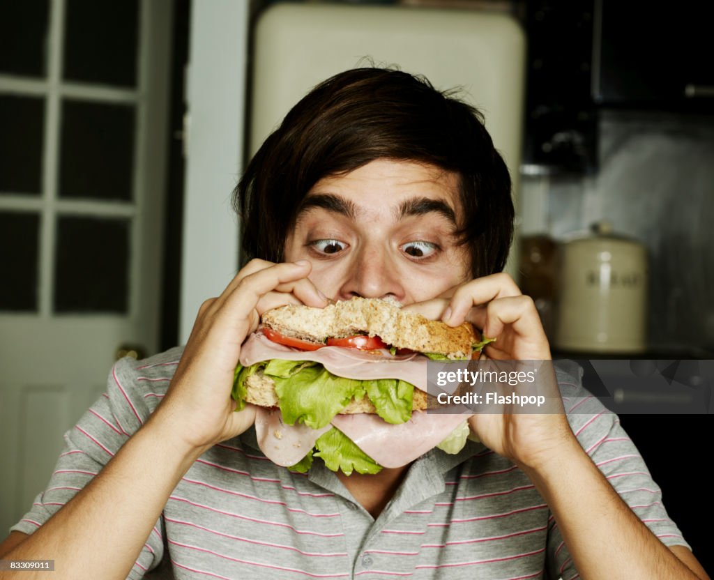 Portrait of man eating sandwich