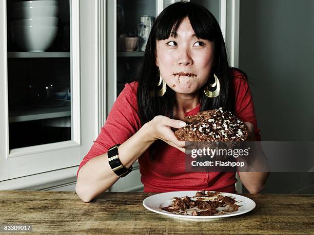 portrait of woman eating chocolate cake - over eating fotografías e imágenes de stock