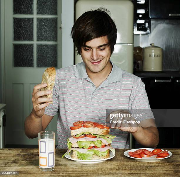 portrait of man making a sandwich - een broodje smeren stockfoto's en -beelden