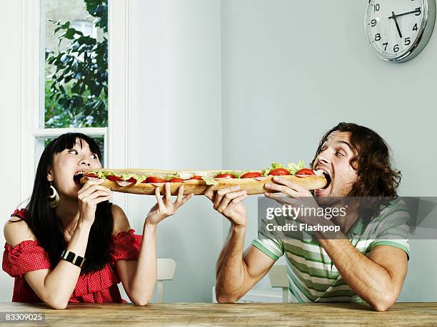 portrait of a couple sharing a baguette - couple cuisine stock pictures, royalty-free photos & images