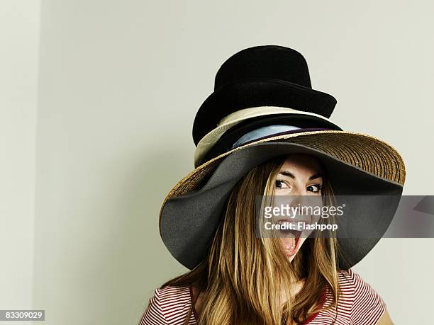 portrait of woman wearing lots of hats - hat foto e immagini stock