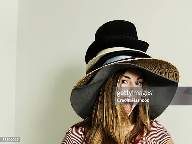 portrait of woman wearing lots of hats - hat stockfoto's en -beelden