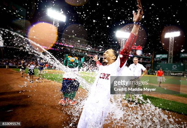Mookie Betts of the Boston Red Sox is doused in water after hitting a walk off two run double to defeat the St. Louis Cardinals 5-4 at Fenway Park on...