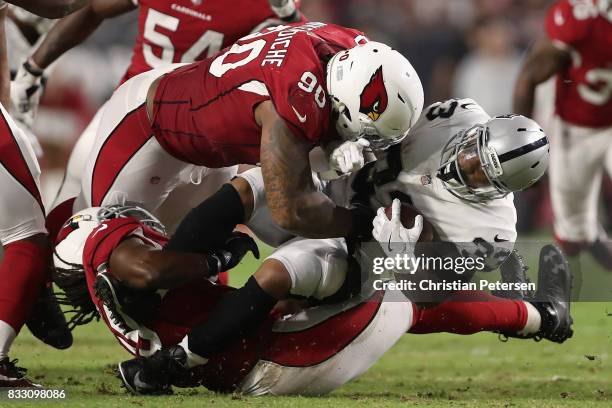 Defensive tackle Robert Nkemdiche of the Arizona Cardinals tackles running back DeAndre Washington of the Oakland Raiders for a loss during the...