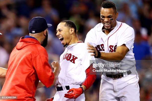 Mookie Betts of the Boston Red Sox celebrates with David Price and Xander Bogaerts after hitting a go ahead two run double to defeat the St. Louis...