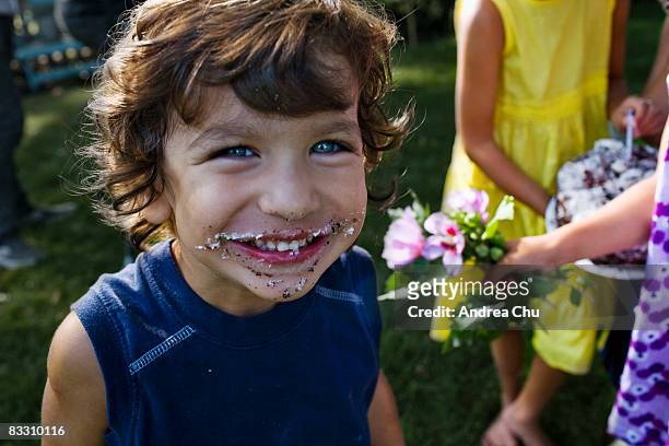 young boy smiling with birthday cake on his face. - essex county new jersey stock pictures, royalty-free photos & images