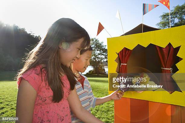 two friends investigating puppet theater in park - puppet show stock pictures, royalty-free photos & images