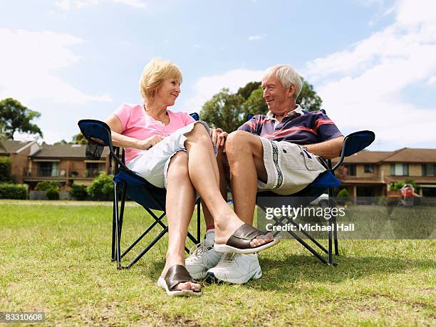 elderly man & woman relaxing in deck chairs  - michael sit stock pictures, royalty-free photos & images