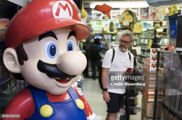Statue of the Nintendo Co. Video-game character Mario stands on display at the Super Potato video game store in the Akihabara district of Tokyo,...