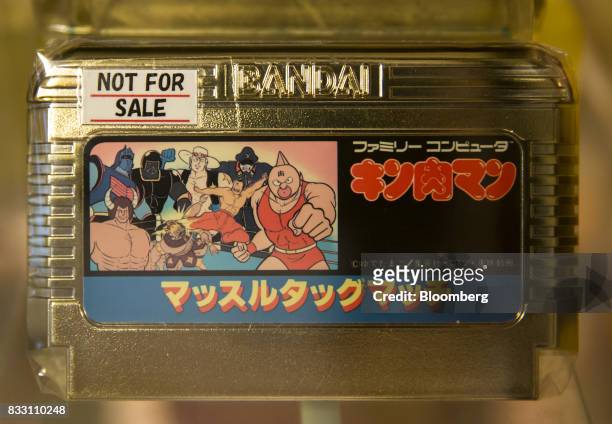 The Kinnikuman Muscle Tag Match gold version video game cartridge for the Nintendo Co. Nintendo Entertainment System /Famicom console is displayed at...