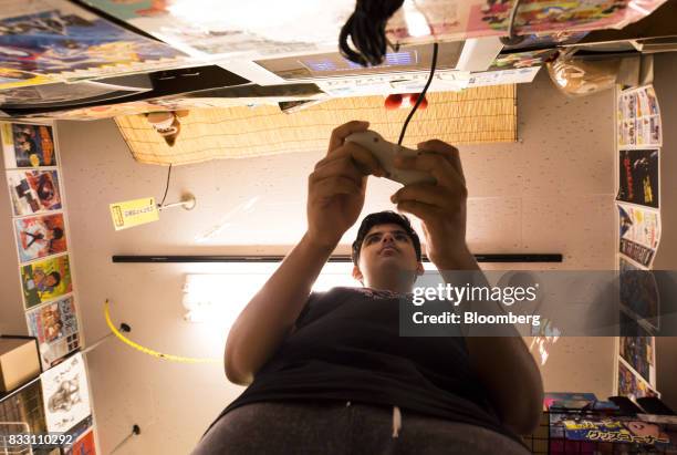 Customer plays a video game on the Nintendo Co. Super Nintendo Entertainment System console at the Super Potato video game store in the Akihabara...