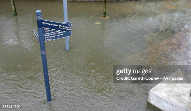 The banks of the River Aire in Leeds city centre are broken as heavy rain falls.