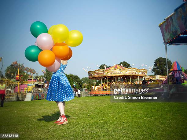 woman with balloons at fair - traveling carnival stockfoto's en -beelden
