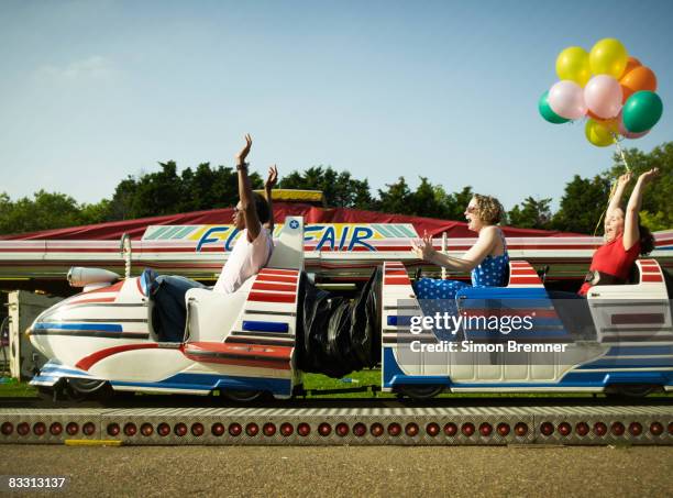 three people on funfair ride cheering - roller coaster side view stock pictures, royalty-free photos & images