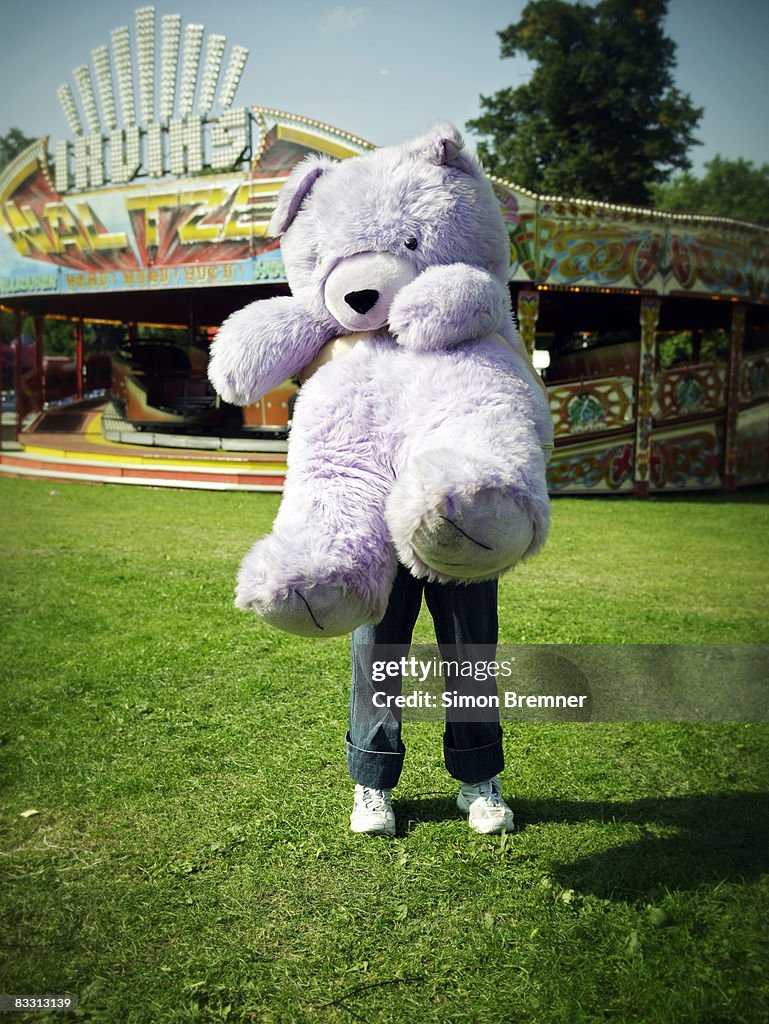 Woman with huge teddy bear at funfair