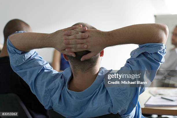 man leans back in office meeting - hands behind head stock pictures, royalty-free photos & images