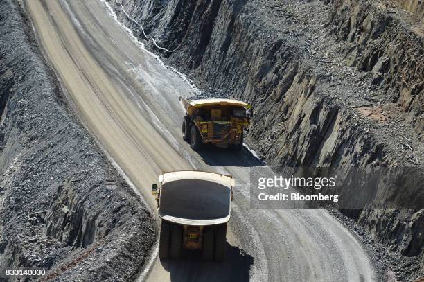 Dump trucks travel along an access ramp of the Invincible mine at the St Ives Gold Mine operated by Gold Fields Ltd. In Kambalda, Australia, on...