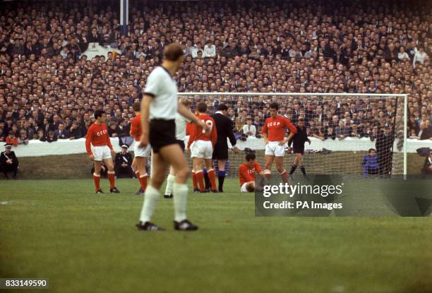 Players look on as a team mate is helped by the trainer Players include Khusainov and Banishevsky