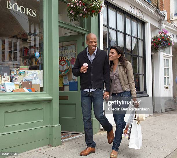 couple walking along street together - kent foto e immagini stock