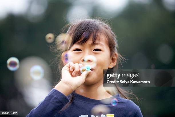 japanese girl blowing bubbles - bellenblaas stockfoto's en -beelden