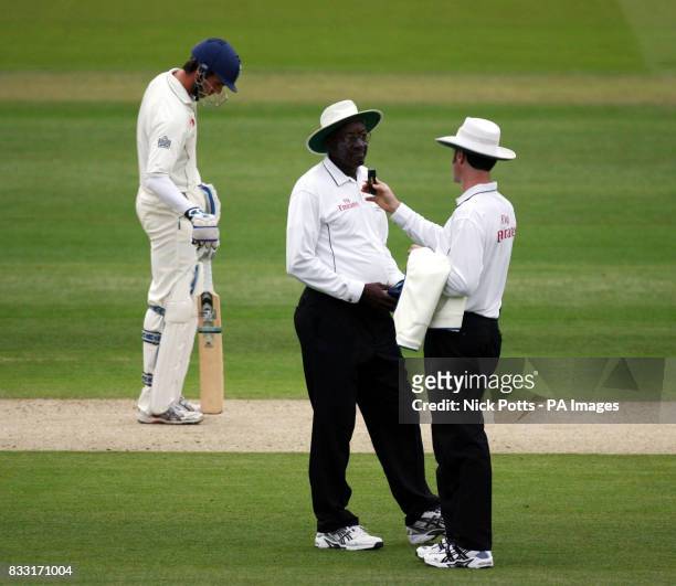 Umpires Simon Taufel and Steve Bucknor take a light reading before taking the players off for bad light during the First npower Test between England...