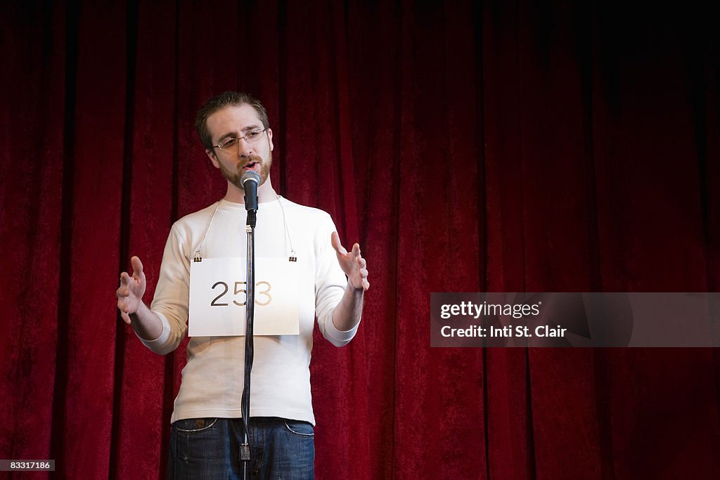 Contestant performing at microphone on stage