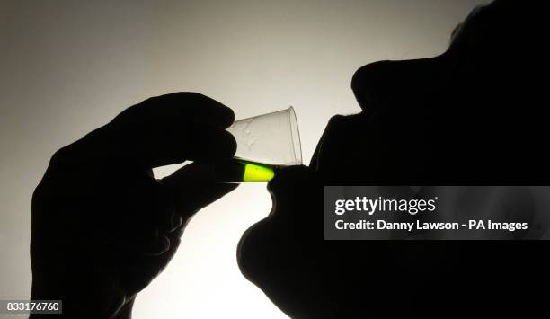 Member of the public takes his prescription of methadone at a Houlihan pharmacy in Glasgow.