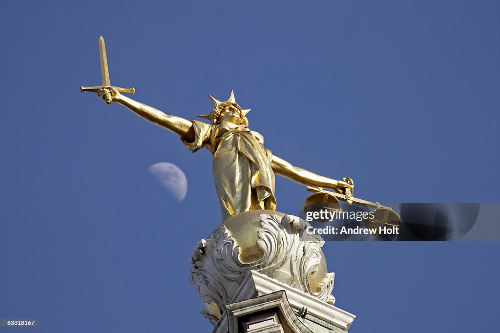 Statue of Justice with moon in blue sky