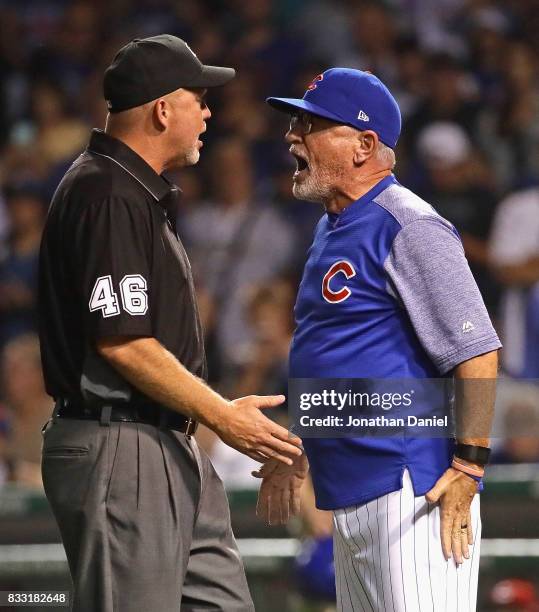 Manager Joe Maddon of the Chicago Cubs aregues with umpire Ron Kulpa in the 9th inning against the Cincinnati Reds at Wrigley Field on August 16,...
