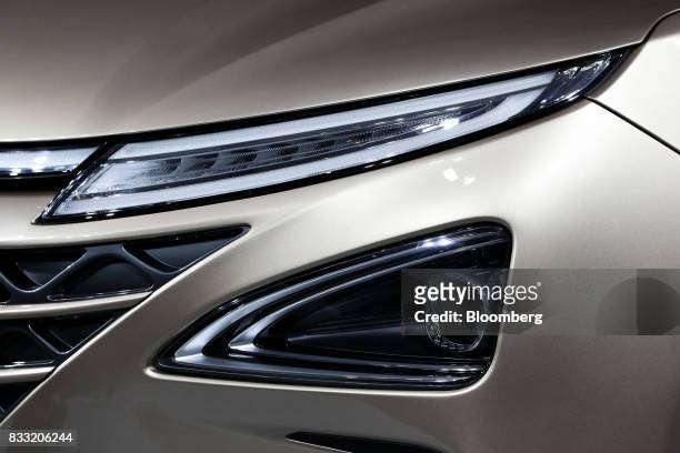 The headlights of a Hyundai Motor Co. Next generation fuel-cell electric sport utility vehicle are displayed during an unveiling event in Seoul,...
