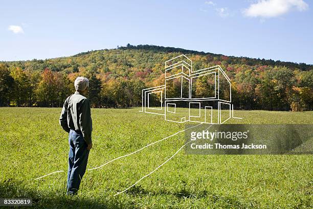 man standing in field admiring imaginary house - day dreaming stock pictures, royalty-free photos & images