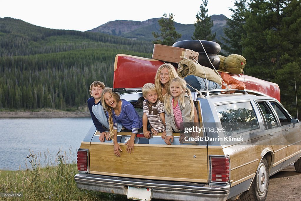 Kids hanging out of back of station wagon