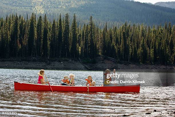 kids canoeing in lake with mountain view - girl rowing boat photos et images de collection