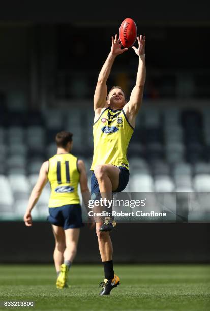 Lachie Henderson of the Cats leaps for the ball during a Geelong Cats AFL training session at Simonds Stadium on August 17, 2017 in Geelong,...