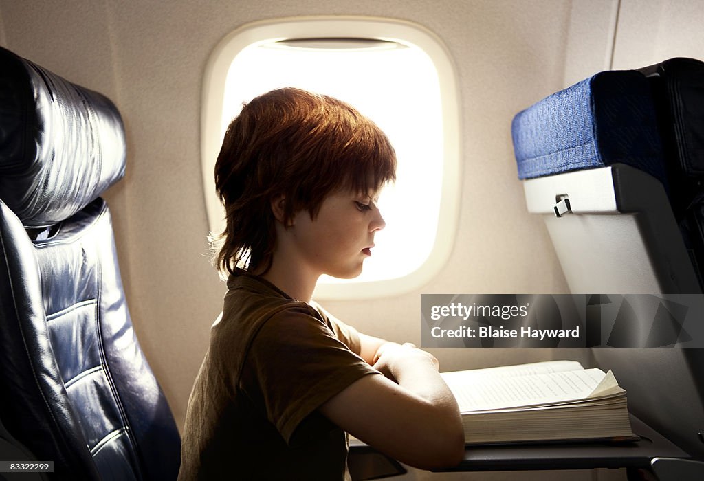Boy reading on a plane