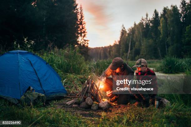 far och son camping tillsammans - campfire bildbanksfoton och bilder