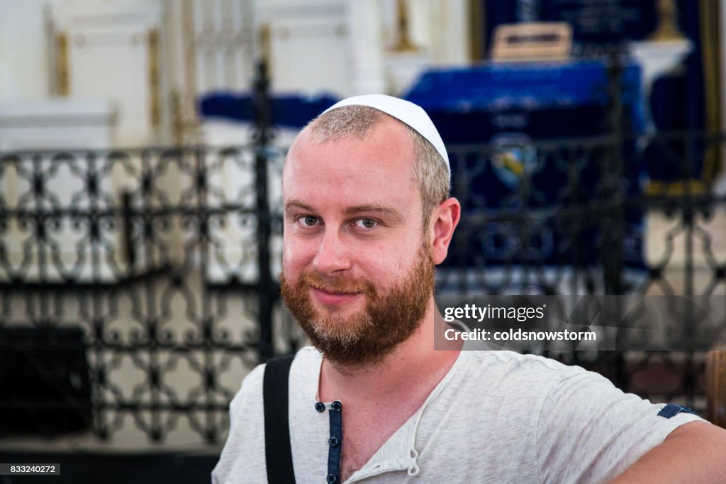Junger jüdischer Mann tragen Käppchen im Inneren der Synagoge